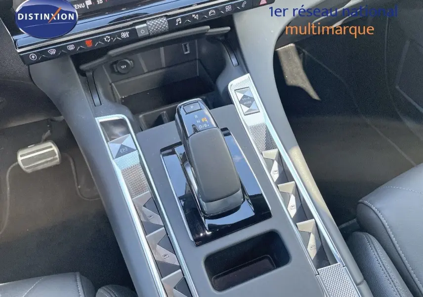 Vue rapprochée de la console centrale du DS7 Crossback E-TENSE 2021, avec levier de vitesse et boutons argentés en losange.
