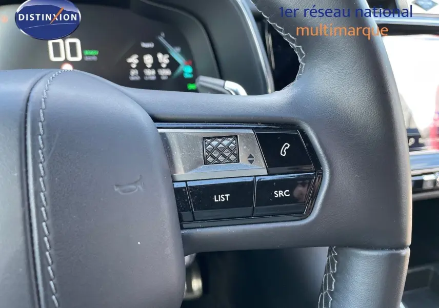Gros plan sur la partie droite du volant en cuir noir du DS7 Crossback E-TENSE 2021, avec commandes intégrées et tableau de bord numérique en arrière-plan.