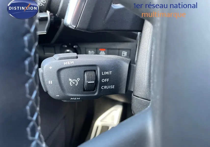 Gros plan sur la commande de régulateur de vitesse au volant d’un DS7 Crossback noir perle métal, intérieur noir.