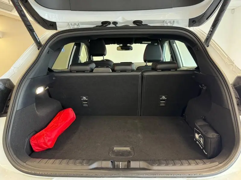 Coffre ouvert vu de l'arrière du Ford Puma blanc Glacier 2022, avec rangement et kit de secours visible.