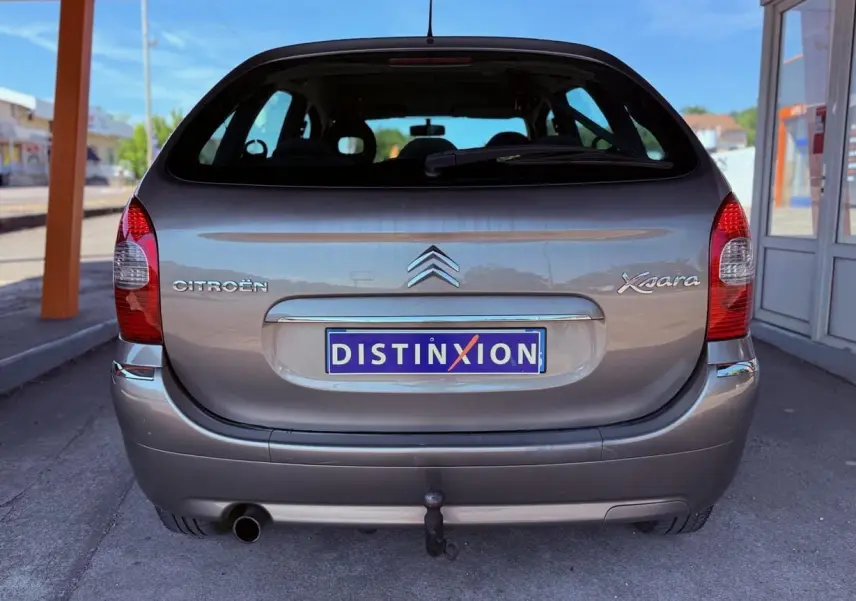 Vue arrière d'une Citroën Xsara Picasso beige 2009 avec attelage de remorque visible sous le pare-chocs.