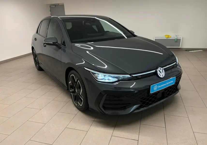 Volkswagen Golf 1.5 eTSI R-Line gris dauphin vue 3/4 avant droit avec phares LED allumés en intérieur.