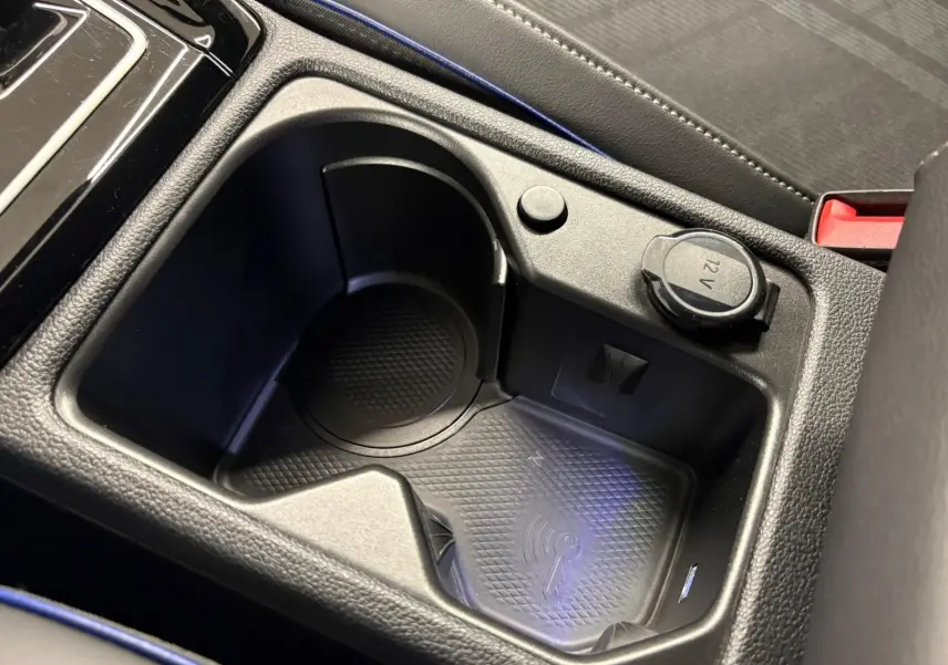 Gros plan sur la console centrale de la Volkswagen Golf 1.5 eTSI R-Line 2025, montrant un espace porte-gobelet et prise 12V.