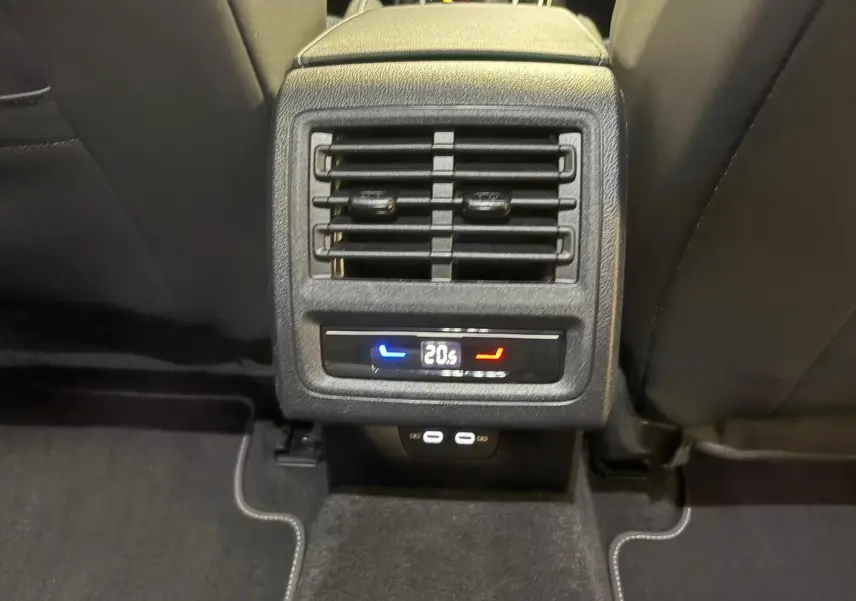 Vue rapprochée de la console arrière de la Volkswagen Golf gris dauphin, avec réglage de climatisation à 20,5°C et ports USB.