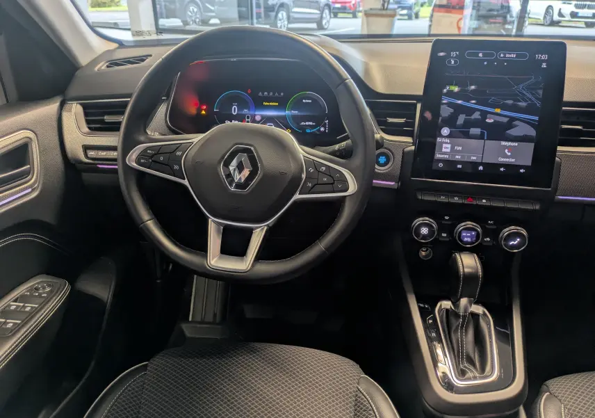 Vue intérieure centrée sur le volant Renault Arkana noir, avec tableau de bord numérique et écran tactile vertical.