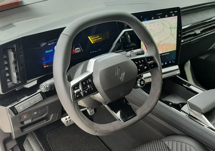Vue intérieure du tableau de bord du Renault Austral 2026, volant multifonction en cuir et écran tactile vertical avec navigation.