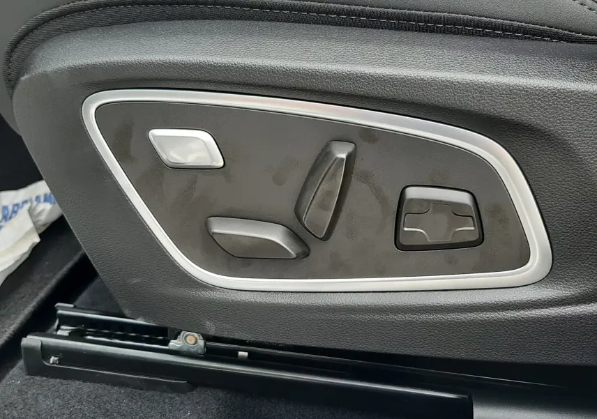Gros plan sur les commandes électriques de réglage du siège conducteur en sellerie noire du Renault Austral 2026.