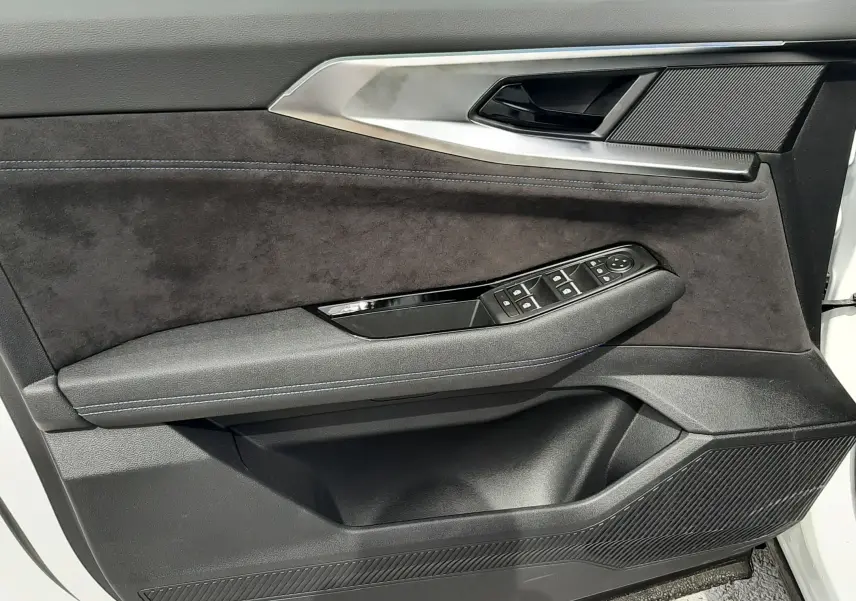 Vue côté gauche de la porte intérieure noire et grise du Renault Austral blanc nacré avec commandes des vitres et miroir.