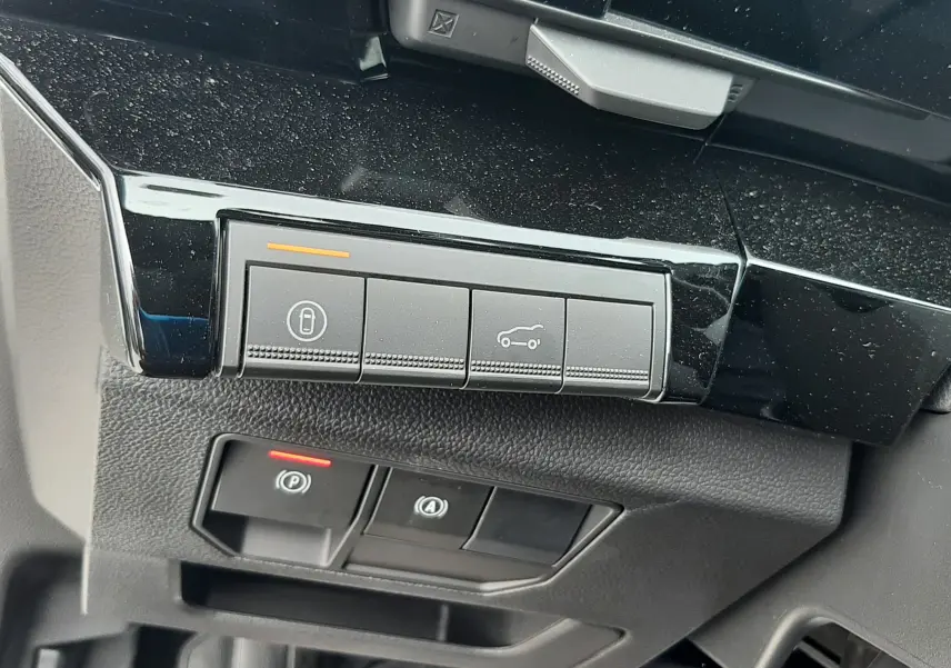 Gros plan sur les commandes sous le tableau de bord côté gauche d’un Renault Austral blanc nacré, finition Esprit Alpine.