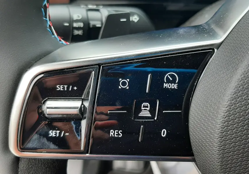 Gros plan sur les commandes du volant noir du Renault Austral 2026, avec surpiqûres tricolores visibles.