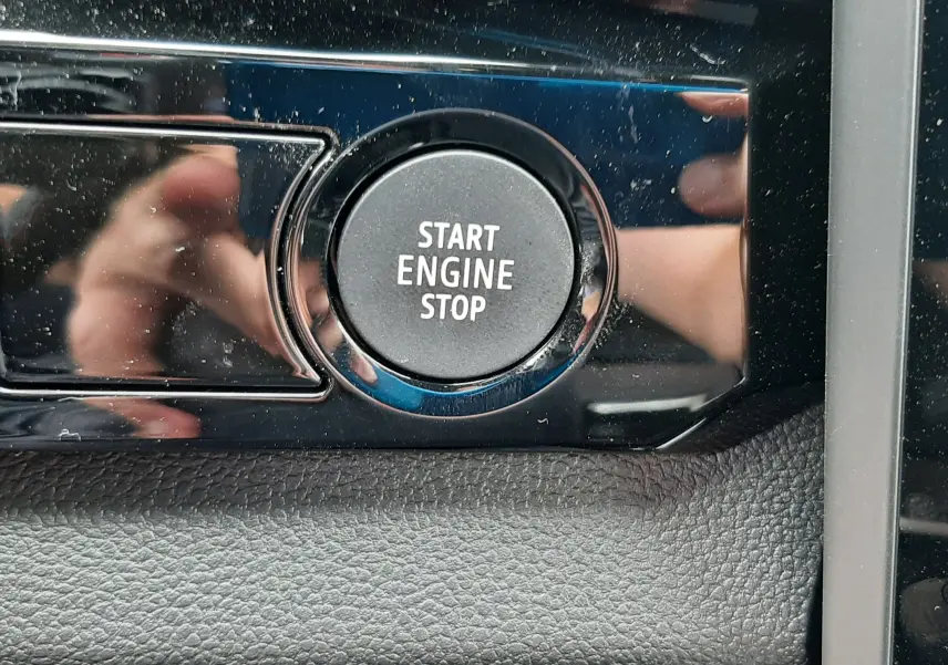 Bouton Start Engine Stop en gros plan sur la console noire brillante intérieure du Renault Austral blanc nacré 2026.