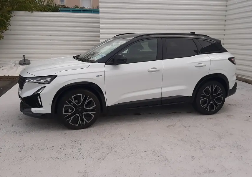 Renault Austral blanc nacré avec toit noir étoilé, vue profil côté gauche, jantes alliage noires et détails noirs contrastants.