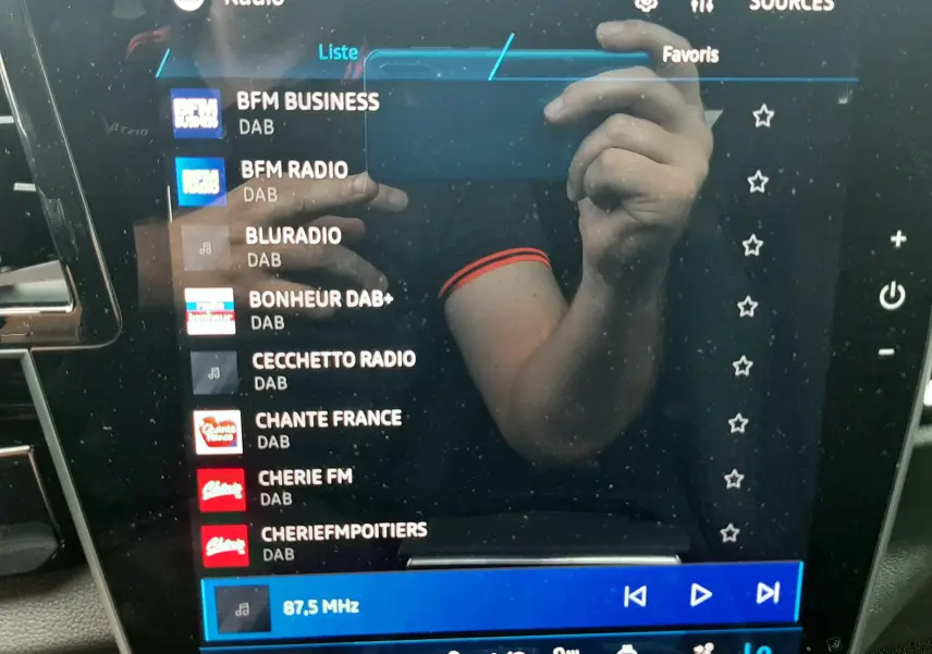 Écran tactile central du Renault Austral 2026 affichant la liste des radios DAB avec interface moderne et commandes climatisation.