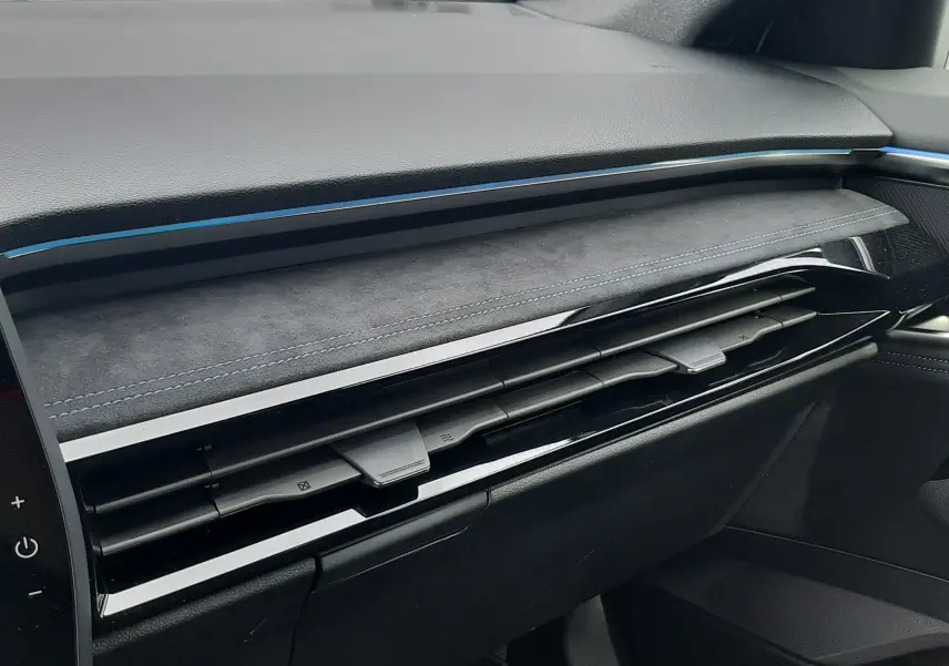 Détail de la planche de bord noire avec surpiqûres bleues et aérateurs horizontaux du Renault Austral full hybrid 2026.