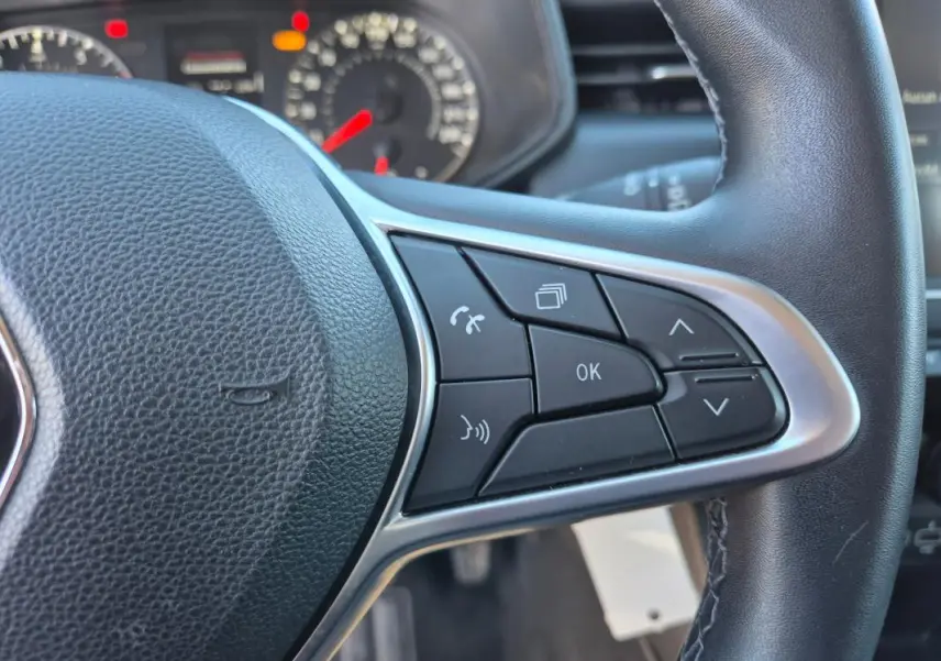 Gros plan sur les commandes multifonctions à droite du volant noir de la Renault Clio V TCe 90 Equilibre 2023.