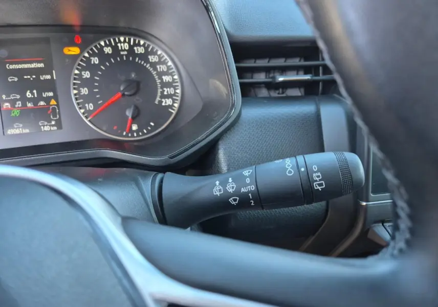 Vue rapprochée du tableau de bord et du commodo de la Renault Clio bleu foncé 2023, avec affichage consommation et vitesse.