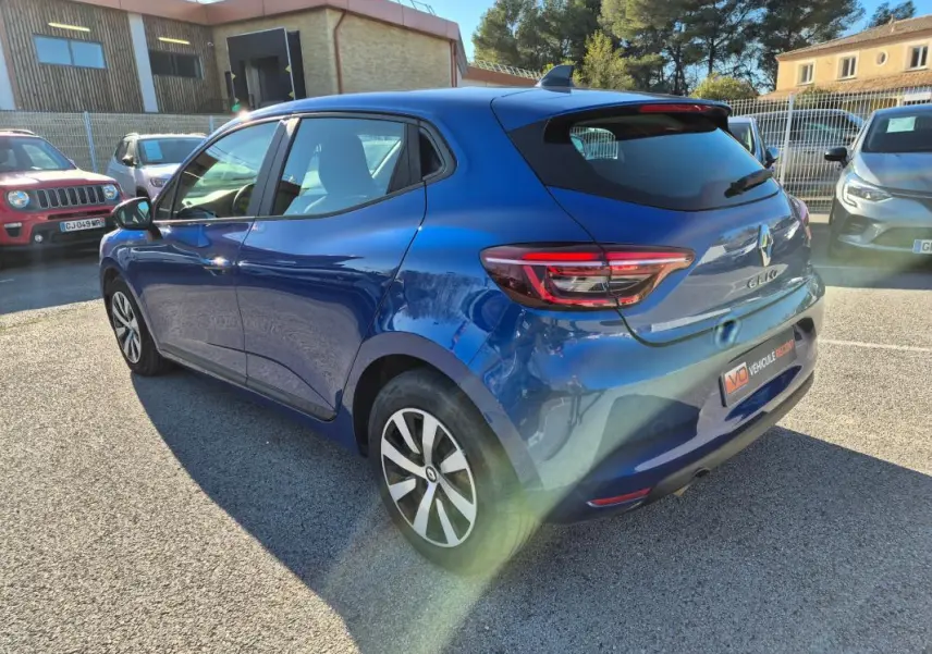 Renault Clio V TCe 90 bleu foncé vue 3/4 arrière droit, avec feux arrière LED et jantes alliage bicolores.