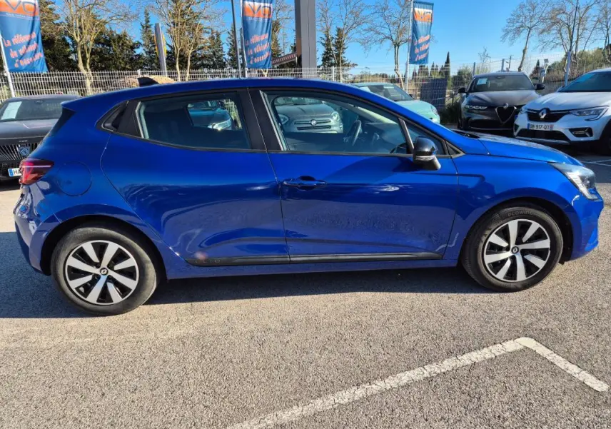 Profil côté gauche d'une Renault Clio V TCe 90 Équilibre bleu foncé 2023, avec jantes alliage et vitres teintées.