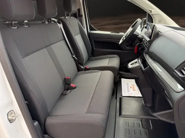 Intérieur avant droit du Citroën Jumpy blanc 2026, montrant sièges tissu gris et tableau de bord moderne.