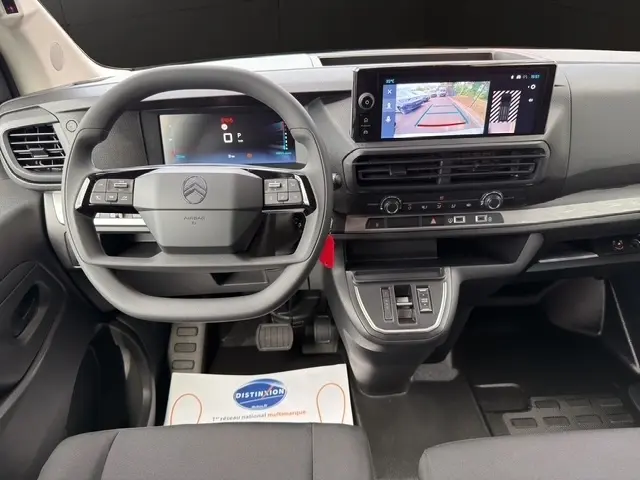 Vue intérieure frontale du tableau de bord du Citroën Jumpy blanc, avec écran tactile affichant la caméra de recul.