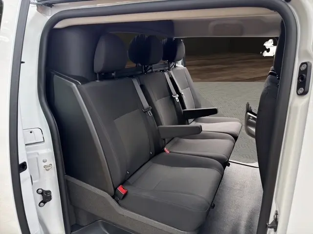 Vue latérale intérieure du siège arrière noir 3 places du Citroën Jumpy blanc avec accoudoir central déployé.