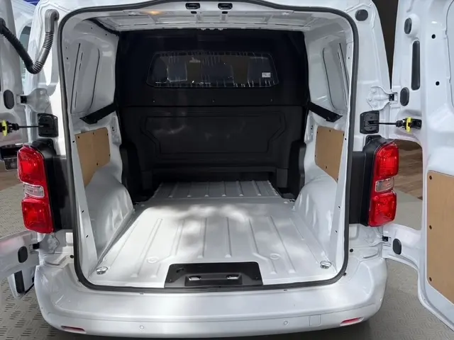 Vue arrière ouverte du Citroën Jumpy blanc, montrant l’espace de chargement vide avec cloison vitrée pleine hauteur.