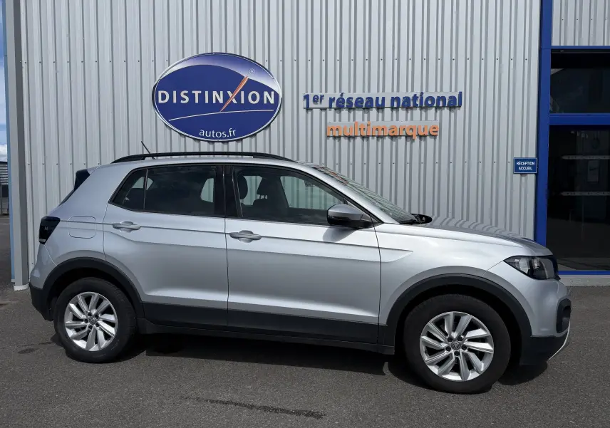 Volkswagen T-Cross gris en profil droit, SUV compact avec jantes alliage et protections noires sur bas de caisse.