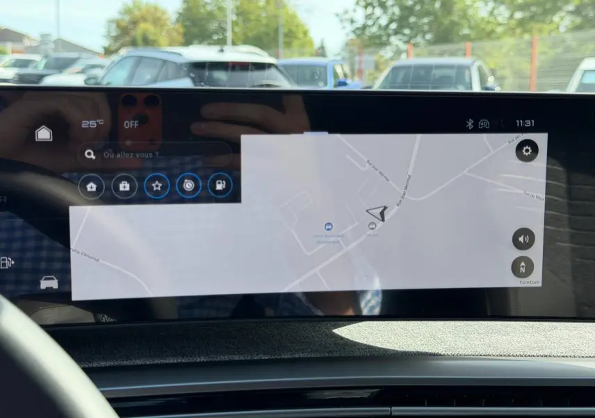 Écran tactile intérieur du Peugeot 3008 noir, affichant la navigation GPS avec reflet du volant et extérieur flou.