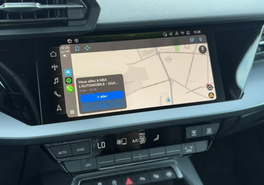 Écran tactile central de l'Audi A3 Sportback 2024 affichant la navigation Apple Car Play en intérieur noir et gris.