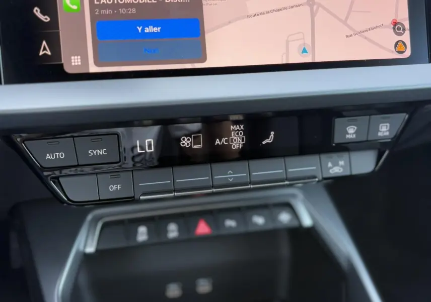 Gros plan sur la console centrale de l'Audi A3 Sportback 2024, affichant les commandes climatisation et écran tactile.