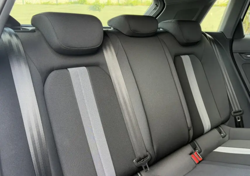 Vue rapprochée des sièges arrière noirs avec bandes grises de l'Audi A3 Sportback 2024 Blanc Arkona.