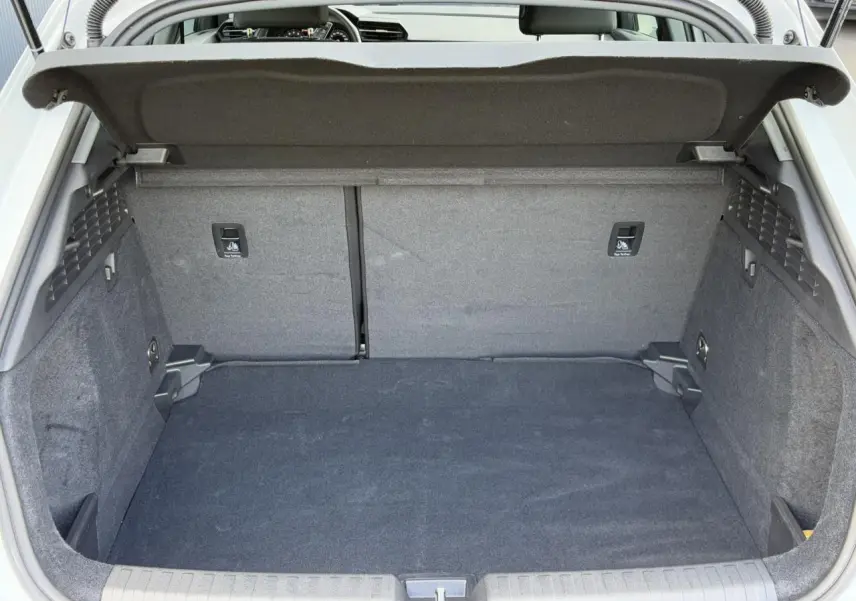 Coffre ouvert vu de l'arrière d'une Audi A3 Sportback blanc Arkona, espace de chargement propre et spacieux.