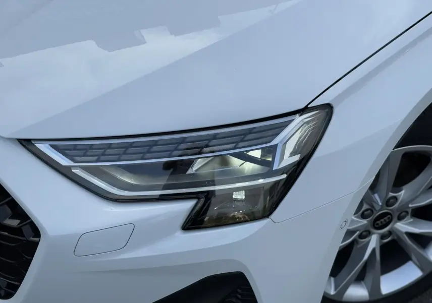 Gros plan sur le phare Matrix LED avant droit et la jante alliage 17 pouces de l'Audi A3 Sportback blanc Arkona.