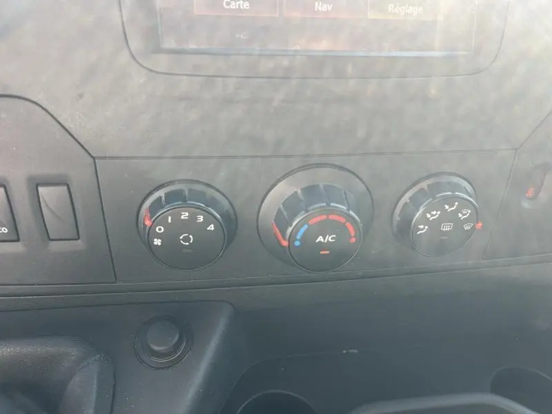 Gros plan sur les commandes de climatisation et ventilation du tableau de bord du Renault Master blanc Glacier 2018.