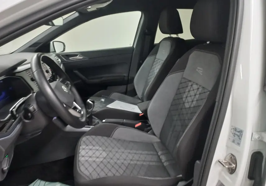 Intérieur avant droit d'une Volkswagen Polo blanc pur 2025, sièges R-Line en tissu et alcantara avec volant cuir.