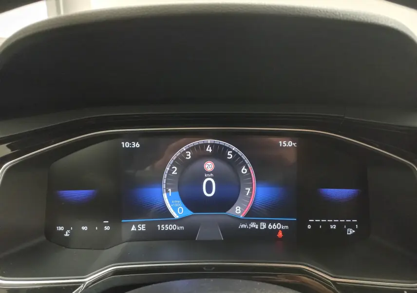 Tableau de bord numérique de Volkswagen Polo blanc, affichant vitesse à 0 km/h et température extérieure 15°C.