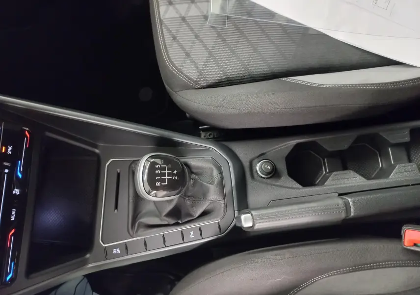Vue rapprochée de la console centrale de la Volkswagen Polo 1.0 TSI 95 BVM5 R-Line avec levier de vitesse manuel et frein à main.