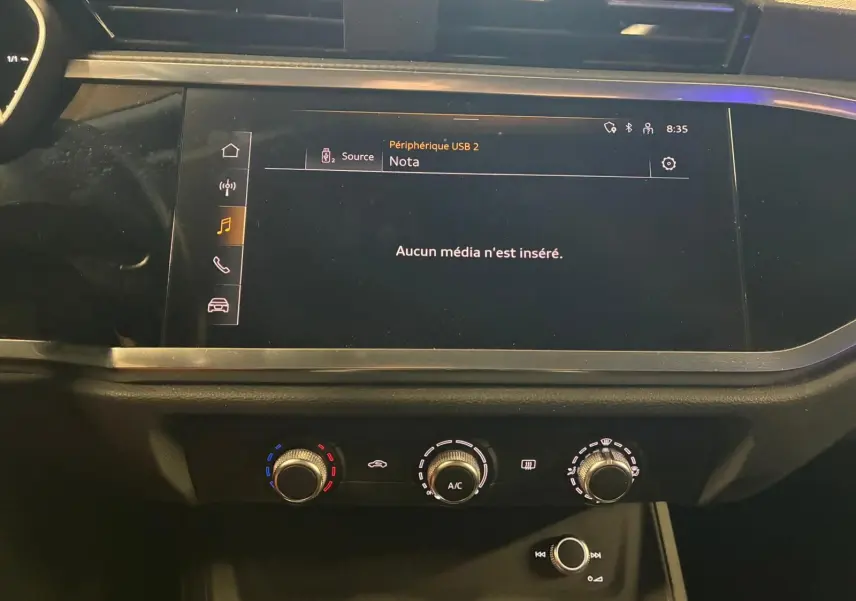 Tableau de bord de l'Audi Q3 Sportback 2022 avec écran tactile et commandes de climatisation en gros plan.