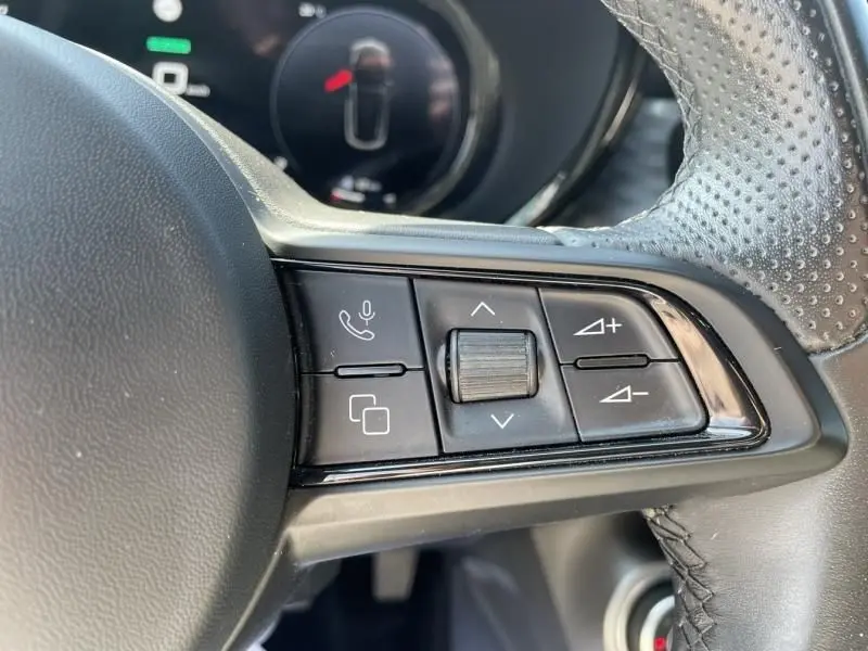 Gros plan sur les commandes au volant côté droit d’un Alfa Romeo Tonale gris foncé, avec molette et boutons multifonctions.