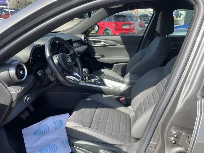 Intérieur de l'Alfa Romeo Tonale 2023 gris foncé, vue côté conducteur montrant sièges et tableau de bord moderne.