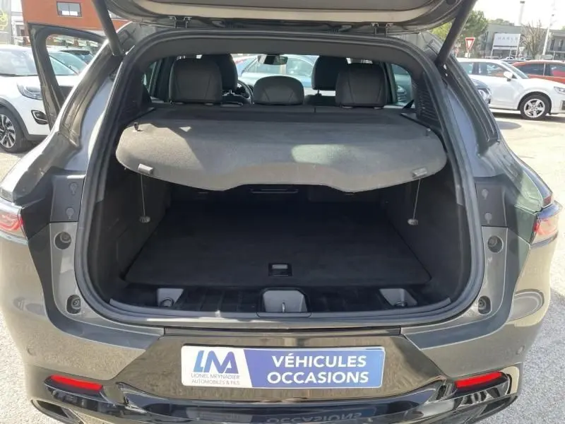 Coffre ouvert en vue arrière d’une Alfa Romeo Tonale gris foncé métal 2023, avec cache-bagages déployé.