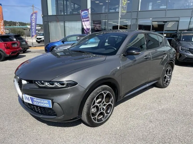 Alfa Romeo Tonale gris foncé métal en 3/4 avant droit, avec jantes distinctives et calandre caractéristique.
