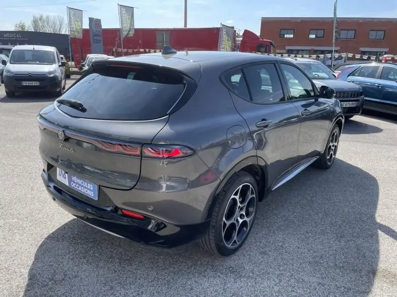 Vue 3/4 arrière droite d'une Alfa Romeo Tonale gris foncé métal 2023 avec feux arrière étirés et jantes distinctives.