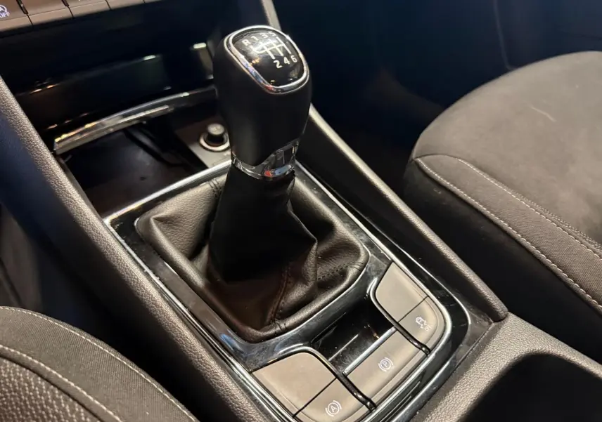 Le levier de vitesses manuel noir du Skoda Karoq 2023, avec console centrale et sièges en tissu gris foncé.