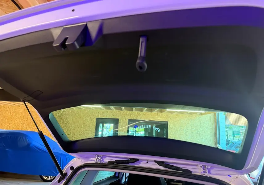 Vue arrière ouverte sur le coffre d’un Skoda Karoq blanc 2023, version 1.5 TSI Ambition Phase 2, en intérieur.