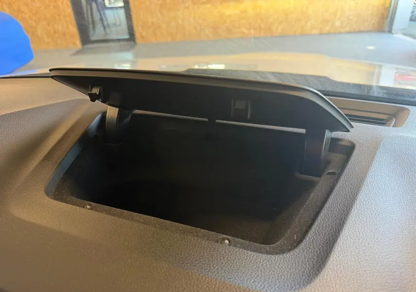 Coffre de rangement ouvert sur le tableau de bord d’un Skoda Karoq blanc, vue intérieure rapprochée.
