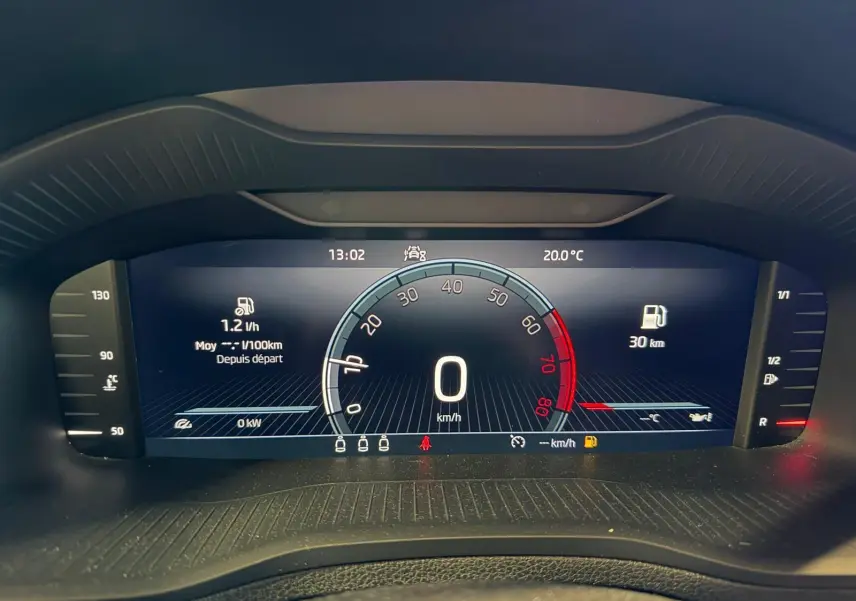 Tableau de bord numérique du Skoda Karoq blanc 2023 affichant la vitesse à 0 km/h et la température extérieure à 20°C.