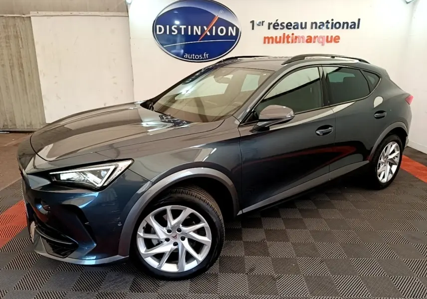 Vue 3/4 avant d'un CUPRA Formentor gris foncé avec jantes argentées dans un showroom intérieur.