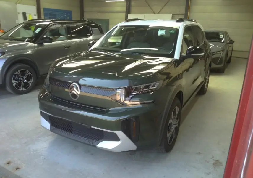 Citroën C3 Aircross 2025 vert Montana avec toit blanc, vue 3/4 avant droit dans un garage intérieur.
