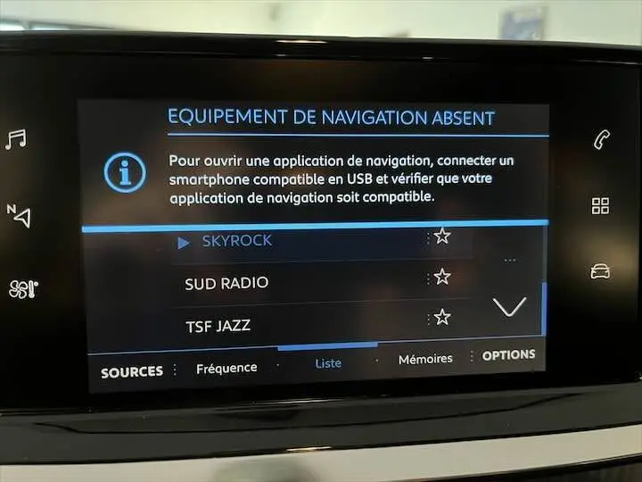 Écran tactile multimédia de la Peugeot 208 2020 affichant l'absence d'équipement de navigation et la liste des radios disponibles.